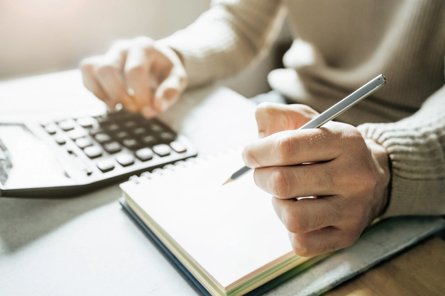 Eine Frau und ihre Mutter berechnen die Kosten für die professionelle Pflege einer älteren Person.